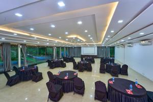 a conference room with tables and chairs and a screen at Coffee Grove Resort in Chikmagalūr +51 photos