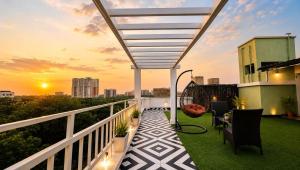 a balcony with a view of the city at sunset at BluO Lake View Studio - NewTown - Terrace Garden in Kolkata +5 photos