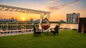 a patio with chairs and a swing on a roof at BluO Lake View Studio - NewTown - Terrace Garden in Kolkata