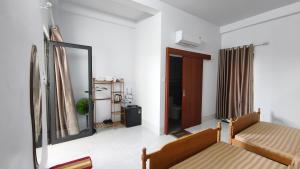 a living room with a couch and a mirror at Mango Homestay Hà Tiên in Hà Tiên
