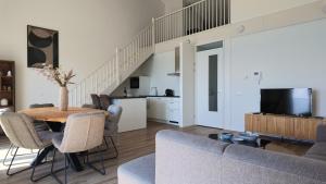 a living room with a couch and a table at Residentie De Zeester | De Wulk in Scherpenisse