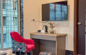 a room with a desk and a red chair at The Botanika Suites in New Town