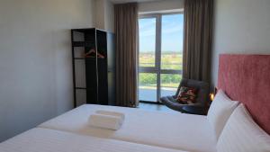 a hotel room with a bed and a window at Residentie De Zeester | De Wulk in Scherpenisse