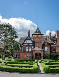 an old mansion with a garden in front of it at Woodlands Park Hotel in Cobham
