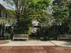 two benches sitting on a sidewalk in a park at BIRD HOTEL in Kamakura