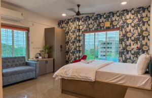 a bedroom with a bed and a chair and windows at The Botanika Suites in New Town