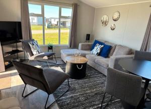 a living room with a couch and a table and chairs at SimpleStayHolland in Westerland