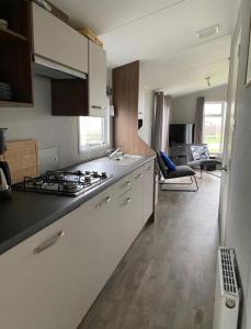 a kitchen with white cabinets and a stove top oven at SimpleStayHolland in Westerland +9 photos