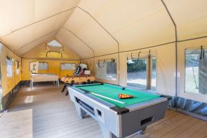 a room with a pool table in a tent at Glamping - Quinta do Cascalhal in Arco de Baúlhe