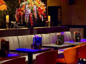 two tables and chairs in a restaurant with flowers at Stadshotel Tante Annie's in Oldenzaal