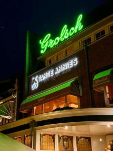 a green neon sign on the side of a store at Stadshotel Tante Annie's in Oldenzaal
