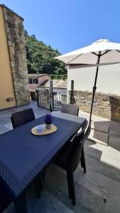 a blue table with an umbrella on a patio at Estate Riomaggiore in Riomaggiore