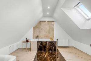 an attic bathroom with a marble floor and a sink at Seaside Home in Fakse Ladeplads +31 photos