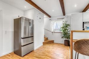 a kitchen with a stainless steel refrigerator and wooden floors at Seaside Home in Fakse Ladeplads
