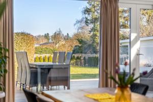 a dining room with a table and chairs and a large window at Seaside Home in Fakse Ladeplads