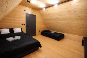 a bedroom with two beds in a room with wooden walls at Top Hill Vista in Sekulić 