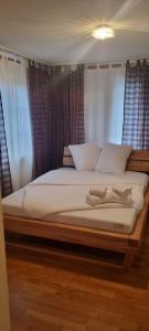 a large bed with white pillows in a bedroom at Sofia Apartment - Aare Jungfrau AG in Wilderswil