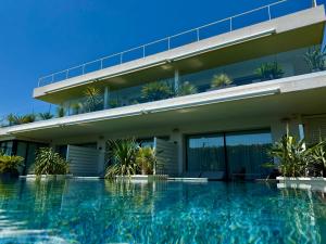 a house with a swimming pool in front of it at VILLA MIAMI in Les Issambres