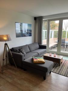 a living room with a couch and a table at Weidevilla 14 auf Ameland in Hollum