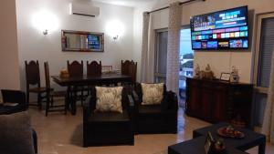 a living room with a television and a dining room at Maison de vacances Casa Rocha in Armação de Pêra