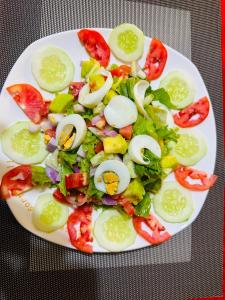 a white plate with a salad with eggs on it at Ebenezer resort hotel in Mbale +27 photos