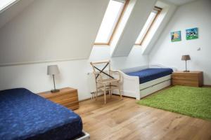 a attic bedroom with two beds and a green rug at Weidevilla XXXL in Hollum