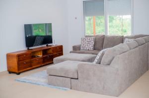 a living room with a couch and a flat screen tv at Coastal Escape Haven in Mchamba Wima