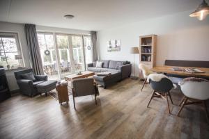 a living room with a couch and a table at Weidevilla 16 in Hollum