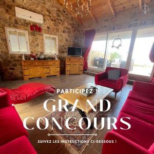 ein Wohnzimmer mit roten Sofas und einem Fernseher in der Unterkunft Charming chalet in Douar el Haj Mohammed