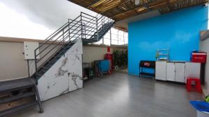 a room with a staircase and a blue wall at Mango Homestay Hà Tiên in Hà Tiên