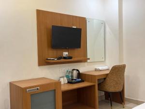 a room with a desk with a television and a chair at The Barrel House, Varanasi in Varanasi