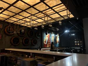 a restaurant with a counter and a person in a room at The Barrel House, Varanasi in Varanasi
