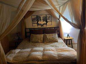 ein Schlafzimmer mit einem Himmelbett in der Unterkunft Charming chalet in Douar el Haj Mohammed