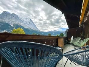a balcony with two chairs and a view of mountains at Bodmi on the top Apartment - Aare Jungfrau AG in Grindelwald