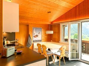 a kitchen with a dining room table and chairs at Bodmi on the top Apartment - Aare Jungfrau AG in Grindelwald