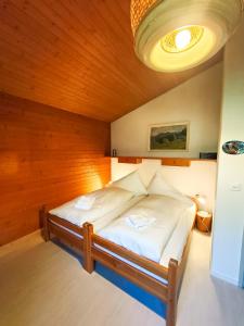 a bedroom with a bed with a wooden ceiling at Bodmi on the top Apartment - Aare Jungfrau AG in Grindelwald