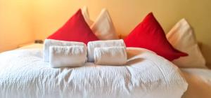 a bed with red and white pillows on it at Bussalp Apartment - Aare Jungfrau AG in Grindelwald