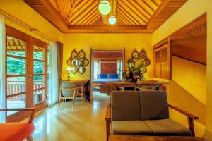 a living room with a couch and a table at Rama Phala Resort & Spa in Ubud