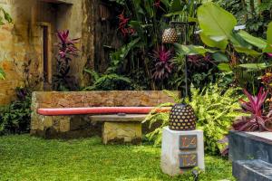 a garden with a bench in the grass at Rama Phala Resort & Spa in Ubud