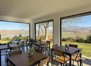 a restaurant with tables and chairs and large windows at Mable's BnB in Retreat