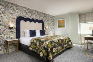 a bedroom with a bed with a floral bedspread at The Grand Hotel in Malahide