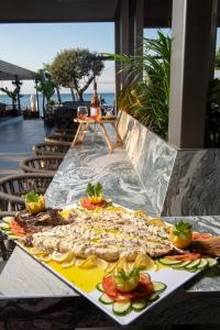 a table with a tray of pizza on it at Ostria Sea Side Hotel in Hanioti