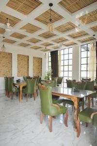 a dining room with tables and green chairs at Kunwarsa villa in Udaipur