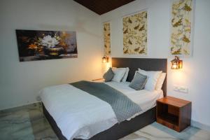 a bedroom with a large bed with white sheets and pillows at Kunwarsa villa in Udaipur