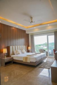 a bedroom with a large bed and a large window at SOLARAA iNN in Anjuna +56 photos
