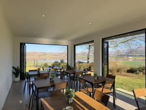 a restaurant with tables and chairs and large windows at Mable's BnB in Retreat