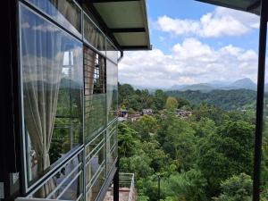 a window of a building looking out at the mountains at Sunset Inn in Kandy