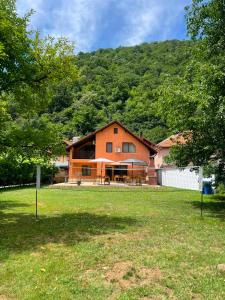 an orange house in front of a mountain at Casa Bianca in Băile Herculane