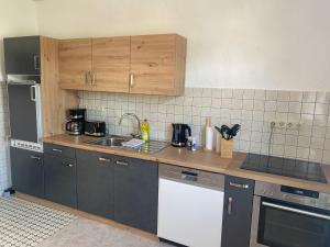 a kitchen with a sink and a counter top at Ferienwohnung am Oechsenberg in Unterbreizbach +2 photos