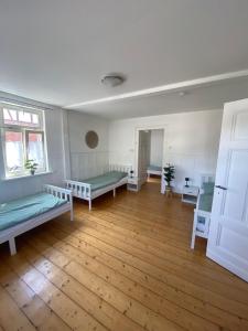 a large room with two beds and a wooden floor at Ferienwohnung am Oechsenberg in Unterbreizbach